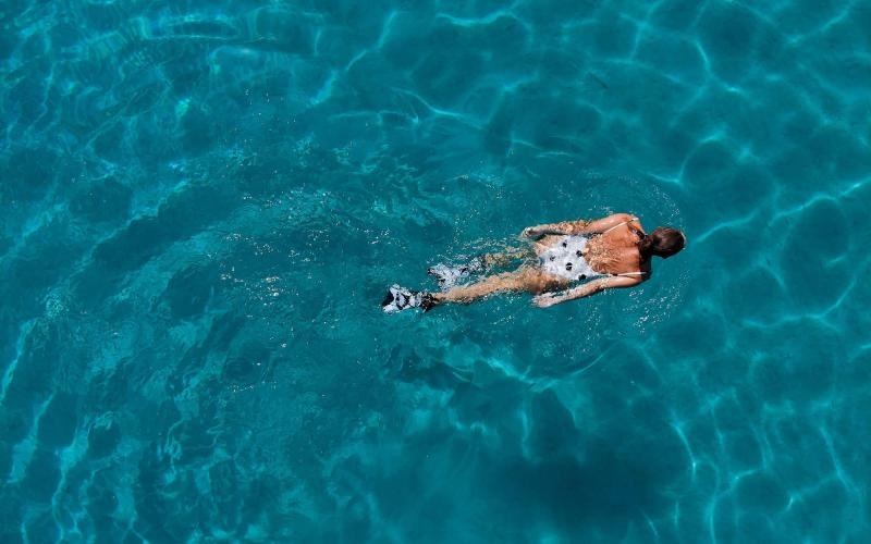 overhead shot of a woman swimming in a pool